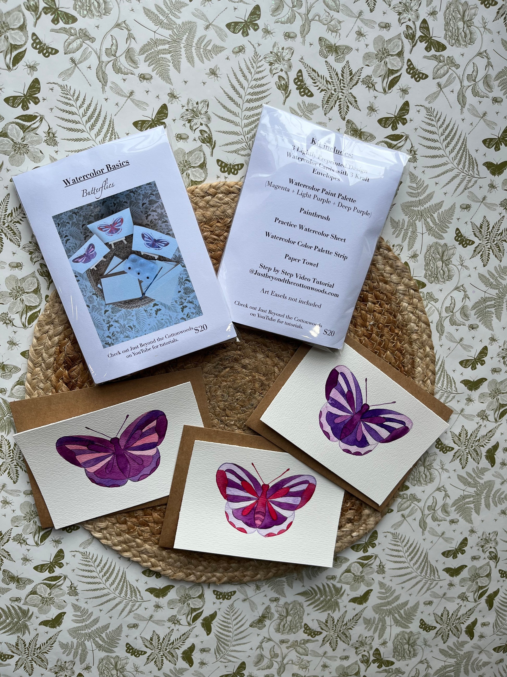 Butterfly-themed greeting cards and stationery on a textured surface with floral patterns.