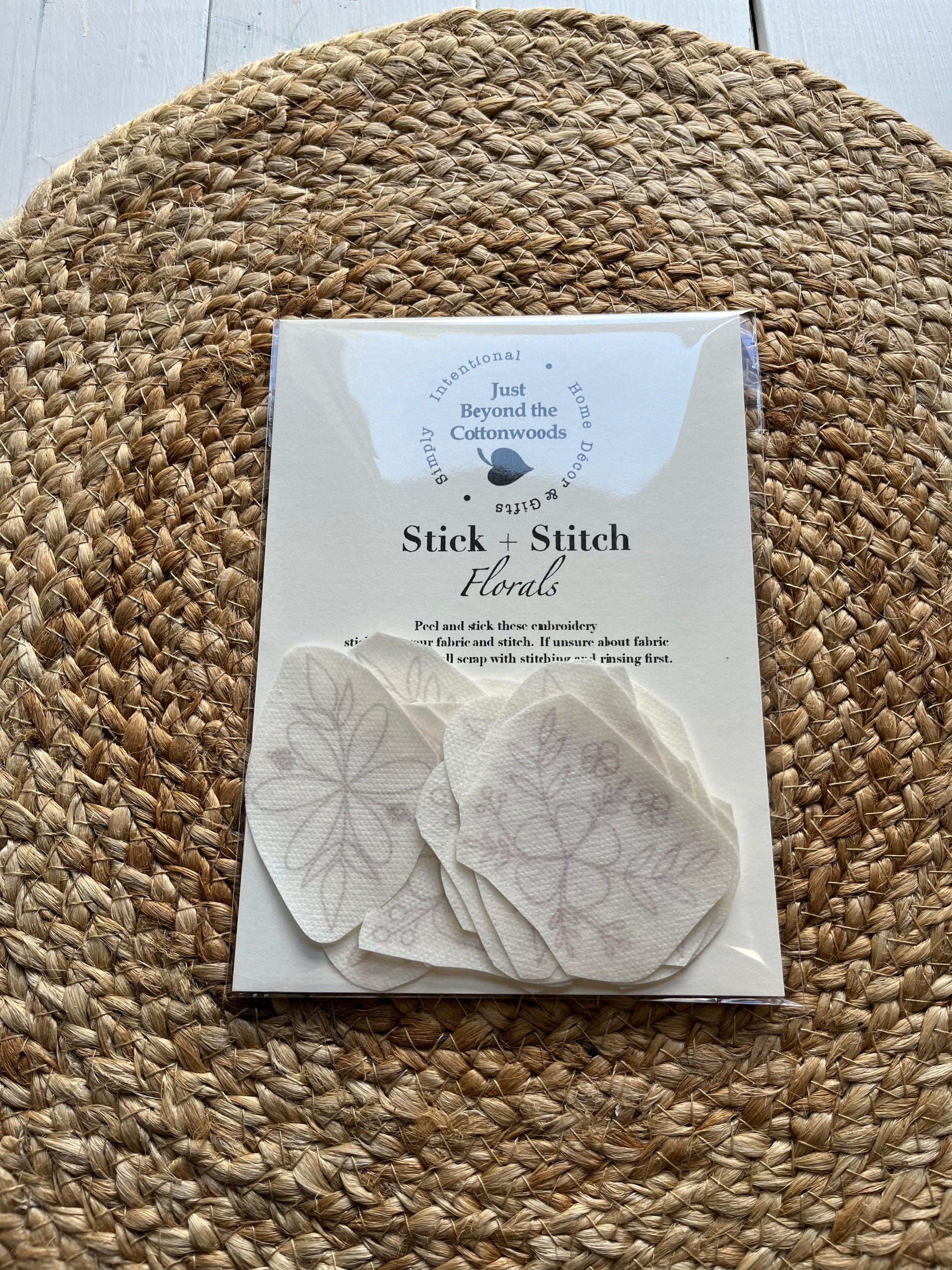Packaging for 'Stick-n-Stitch' embroidery patterns, showing the product name Florals and a few examples of the embroidery designs on a woven mat background.
